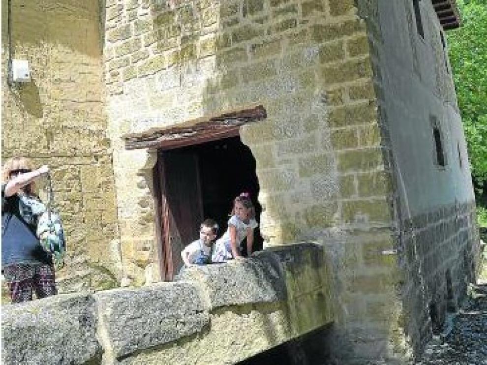 Unos visitantes, junto a la puerta de entrada al Molino.