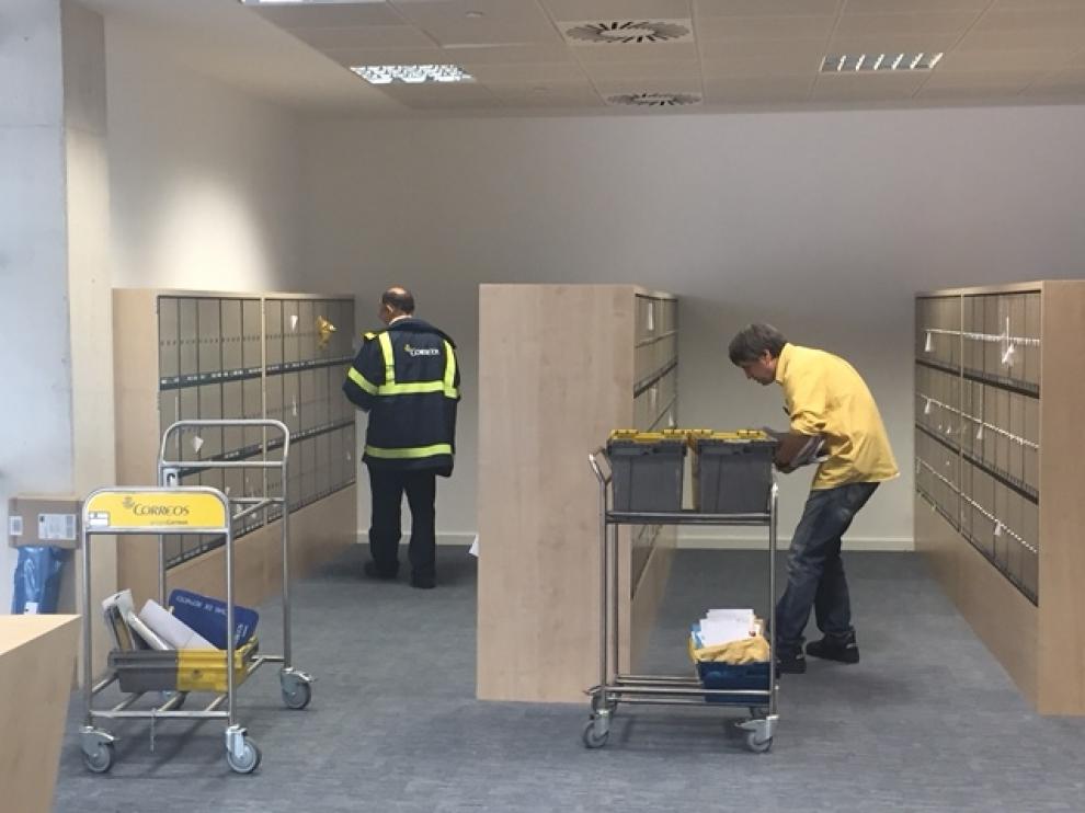 Imagen de dos trabajadores en una oficina de correos.