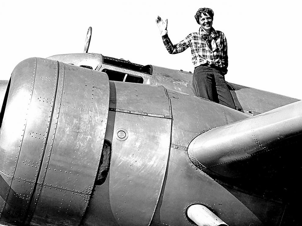 La aviadora saluda apoyada en el fuselaje del 'Lockheed', con el que intentó dar la vuelta al mundo.