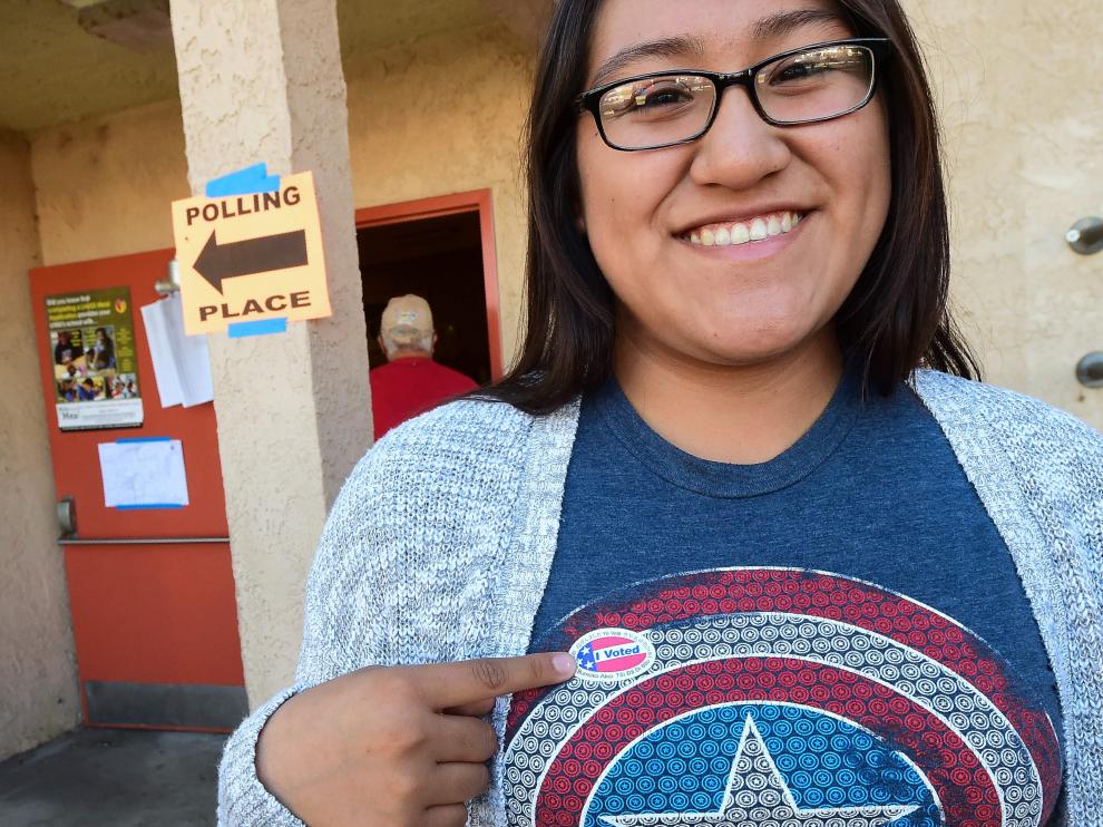 Una latina luce orgullosa la etiqueta con el lema "He votado".
