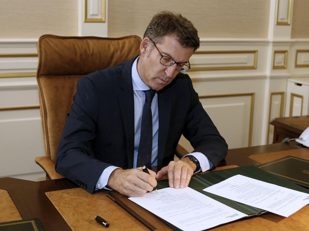 Núñez Feijóo firmando el acta de presidente.