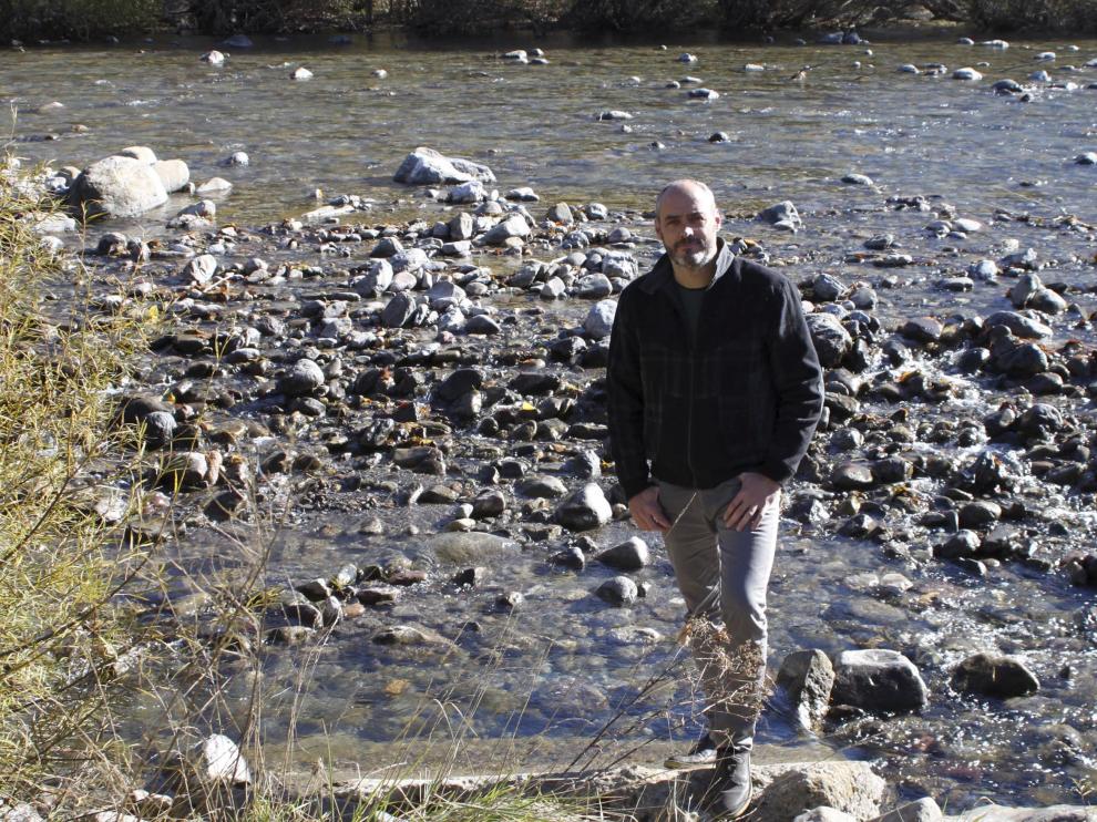 El alcalde de Villanúa, Luis Terrén, en el río Aragón al que vierten las aguas.