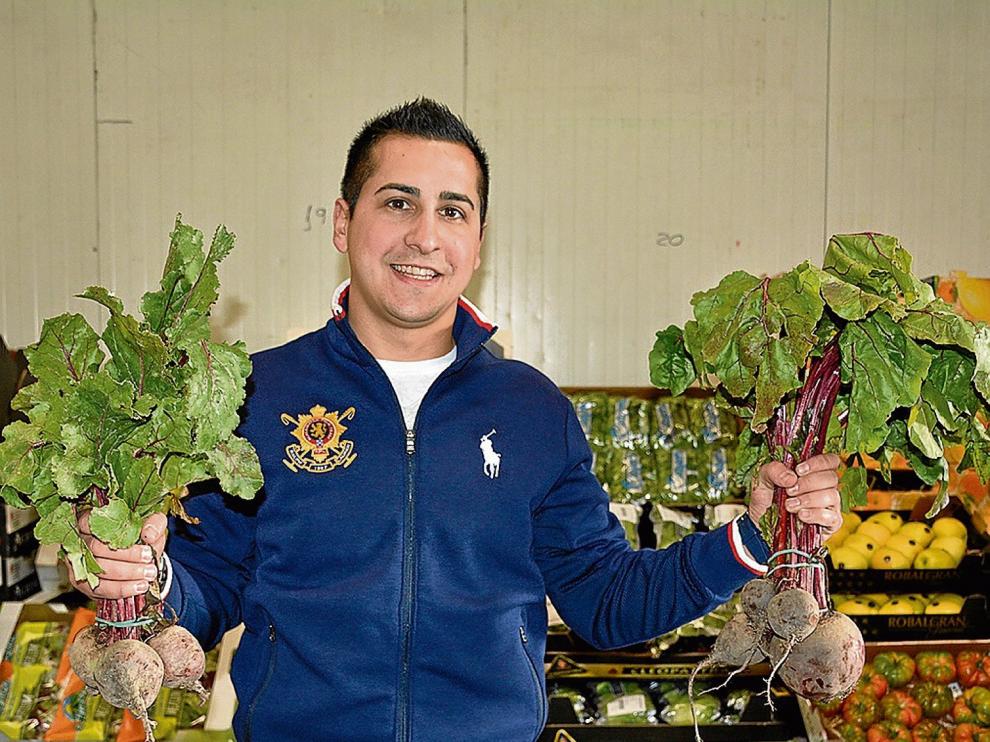 El frutero Adrián Mené, con dos manojos de remolachas frescas.