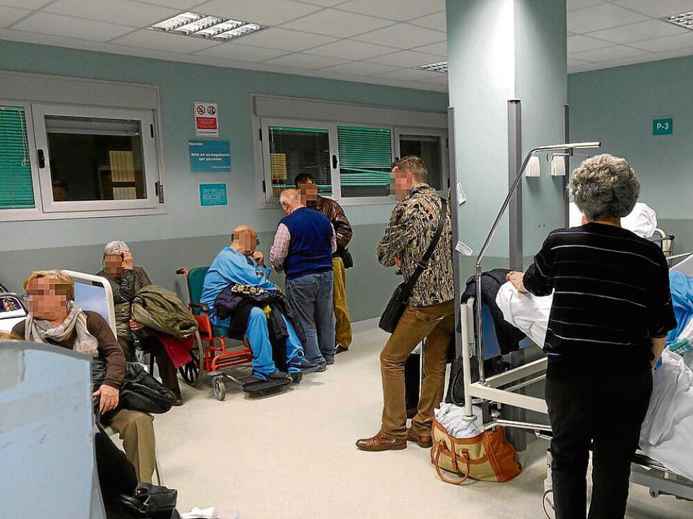Uno de los pasillos del hospital, ayer, con enfermos esperando a ser atendidos.