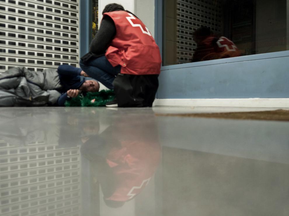 Persona sin hogar en Zaragoza junto a un voluntario de Cruz Roja.