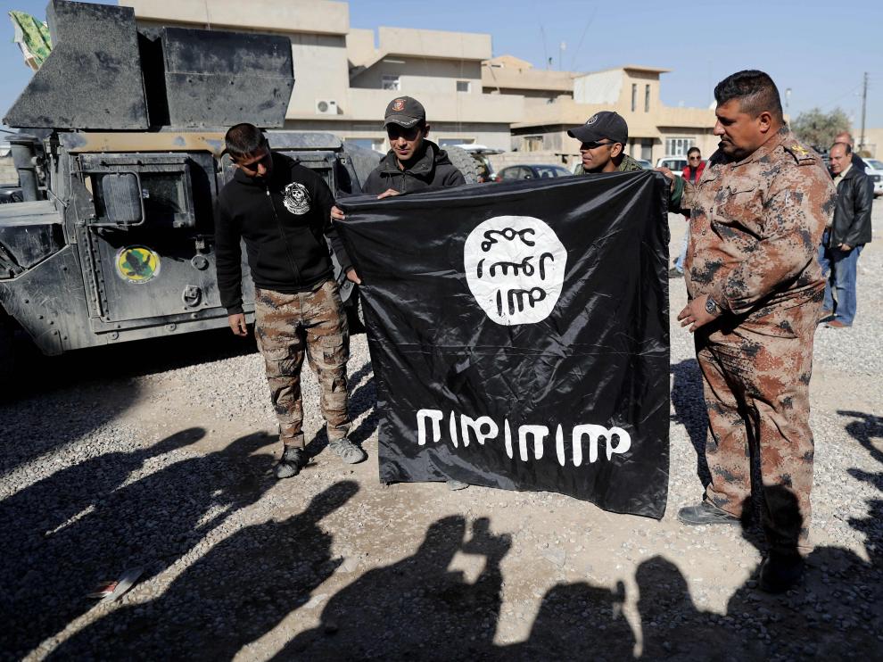Soldados del Ejército de Iraq sostienen una bandera del Estado Islámico puesta al revés