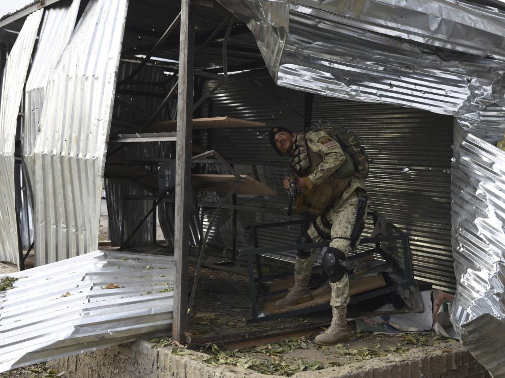 Un soldado inspecciona el lugar donde ha explotado una de las bombas en Jalalabad, Afganistán.