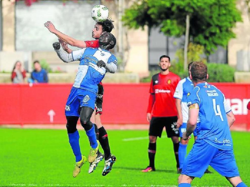Moustapha pugna por un balón de cabeza con un futbolista del Mallorca B, ayer.