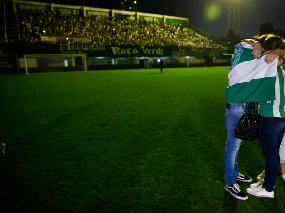 Familiares de jugadores y directivos del Chapecoense saludan a los aficionados durante una vigilia.