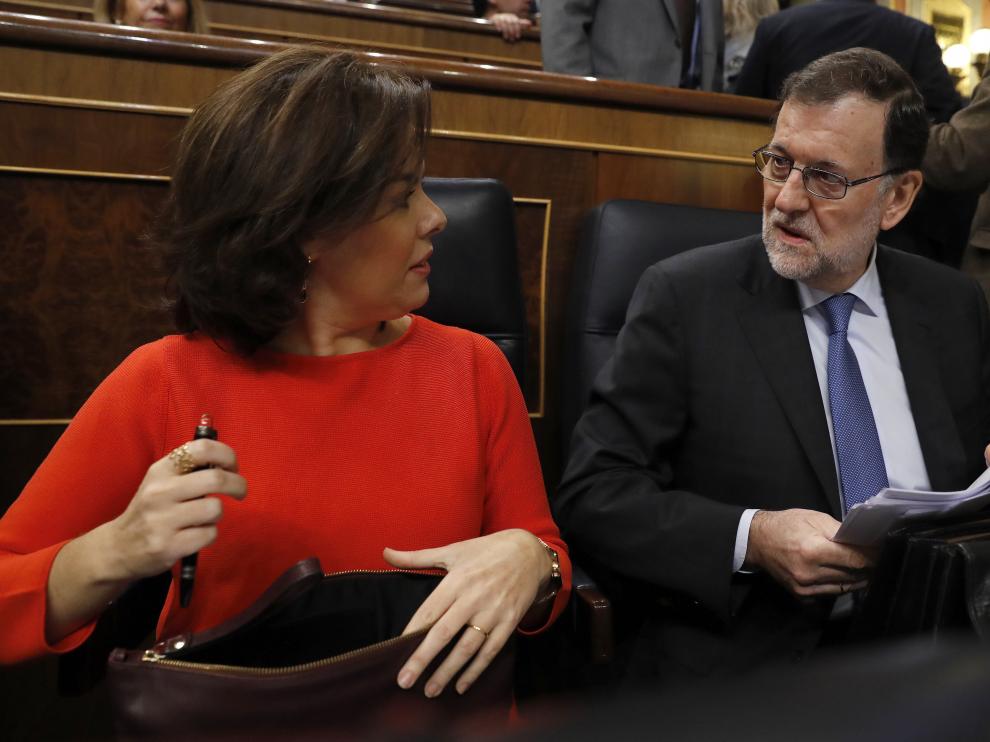 El presidente del Gobierno, Mariano Rajoy (d), conversa con la vicepresidenta, Soraya Sáenz de Santamaría