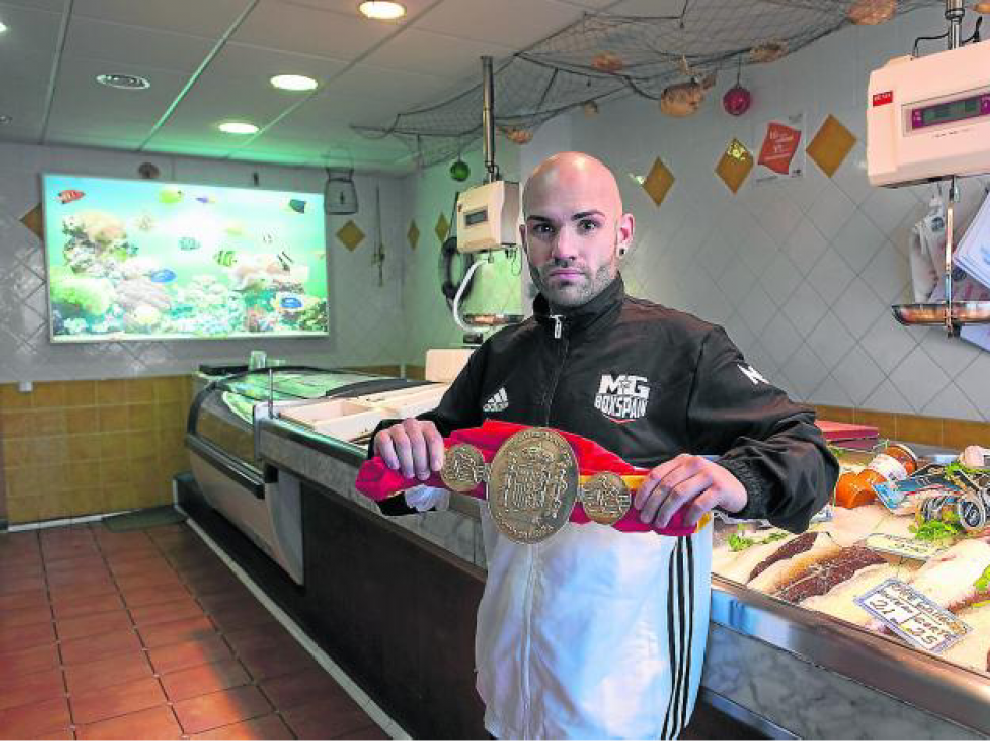 Eloy Iglesias, con el cinturón de campeón de España del peso ligero que ganó el pasado 16 de julio, en la pescadería familiar.
