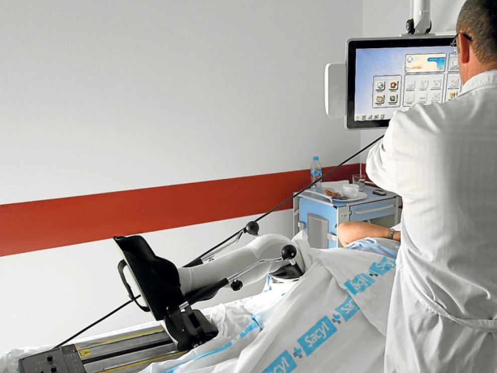 Un profesional sanitario atiende a un paciente ingresado en el Hospital Santa Bárbara.