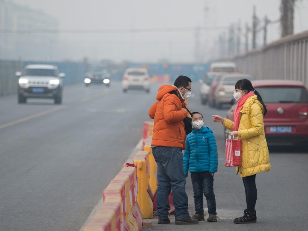 Una familia china con mascarilla por la fuerte contaminación.