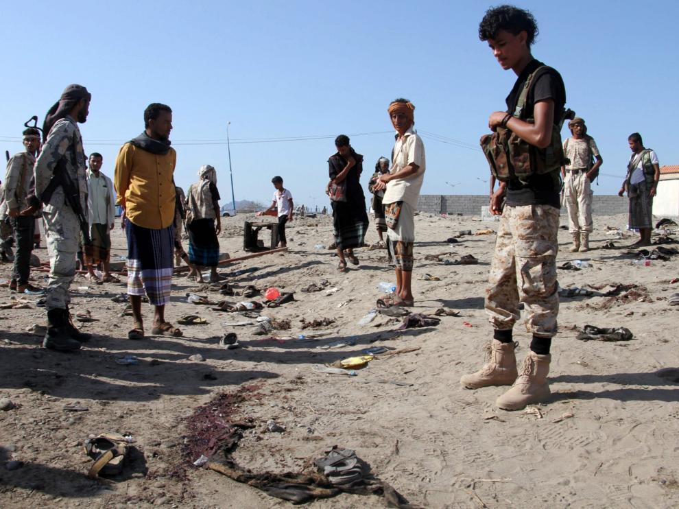 Un grupo de yemenís se reúnen en torno al cuartel atacado, tras el atentado