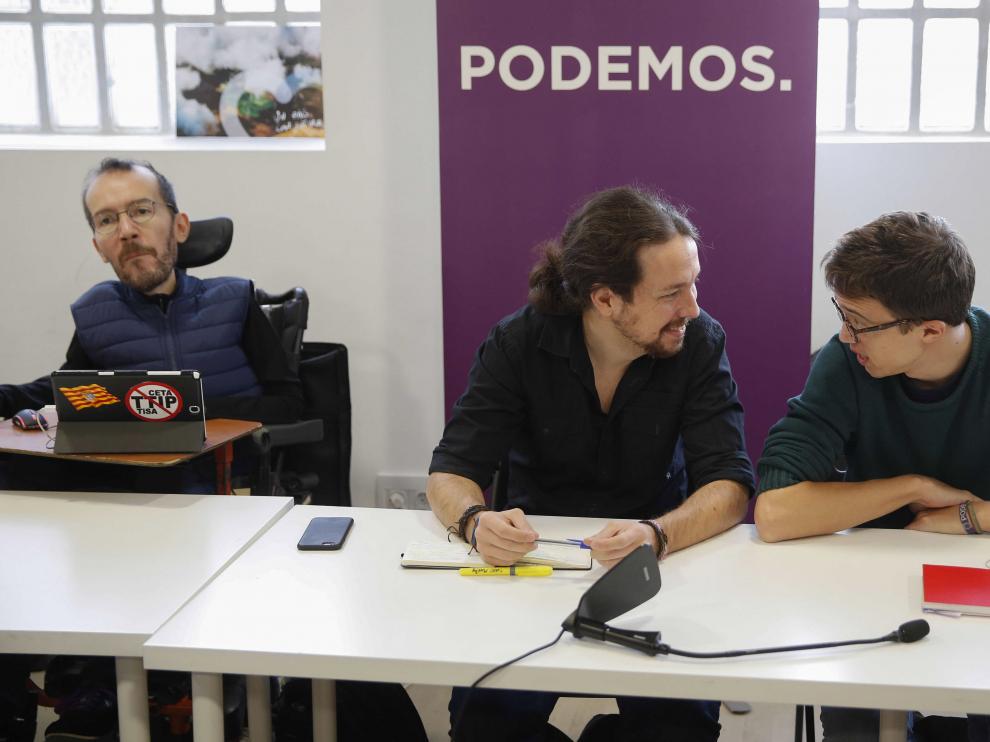 El secretario general de Podemos, Pablo Iglesias (c), y el número dos, Íñigo Errejón, conversan, junto al secretario de Organización, Pablo Echenique