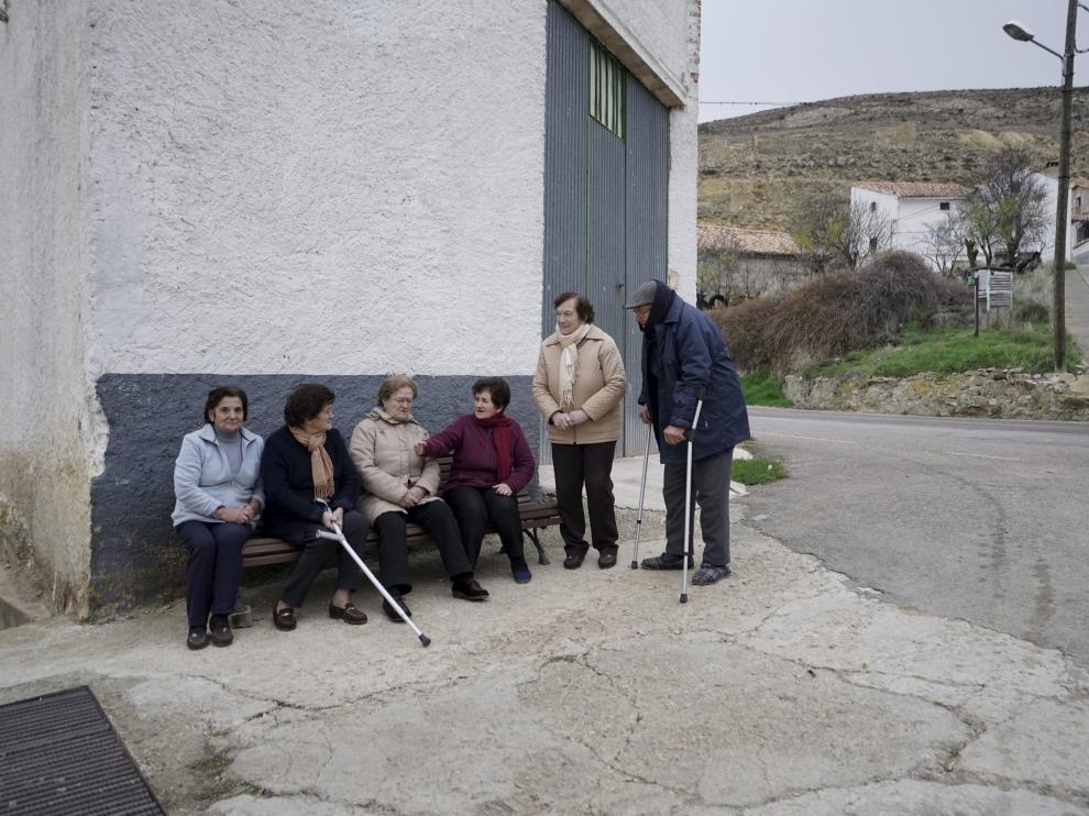 Un grupo de vecinos de Bueña, en el lugar donde cogen el taxi para ir a Monreal del Campo.