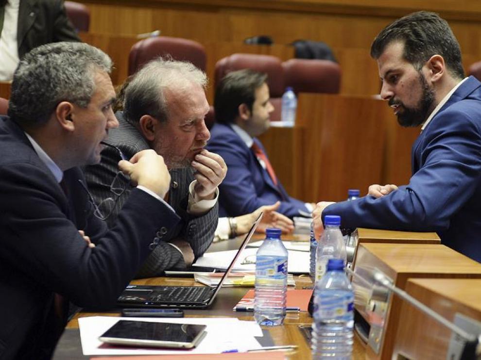 El portavoz del Grupo Parlamentario Socialista, Luis Tudanca (d), conversa con los procuradores Javier Izquierdo (i), y José Francisco Martín (c), durante la sesión plenaria de las Cortes
