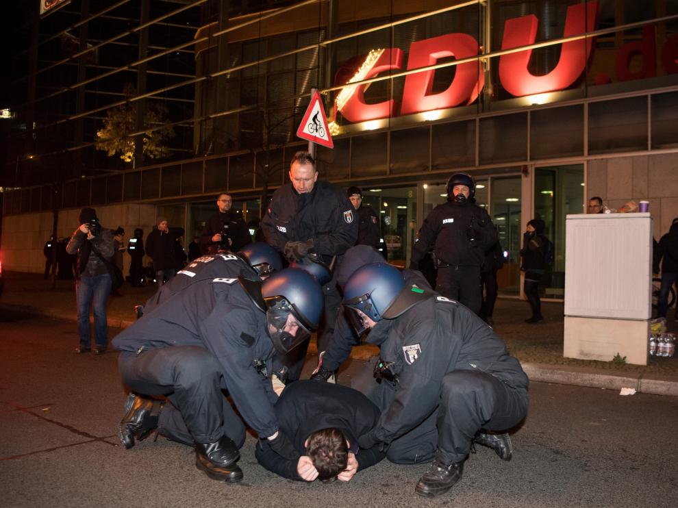 Miembros de la policía antidisturbios arrestan a un hombre durante la vigilia que extremistas de la derecha realizan hoy, miércoles 21 de diciembre de 2016, frente a la Cancillería alemana en Berlín