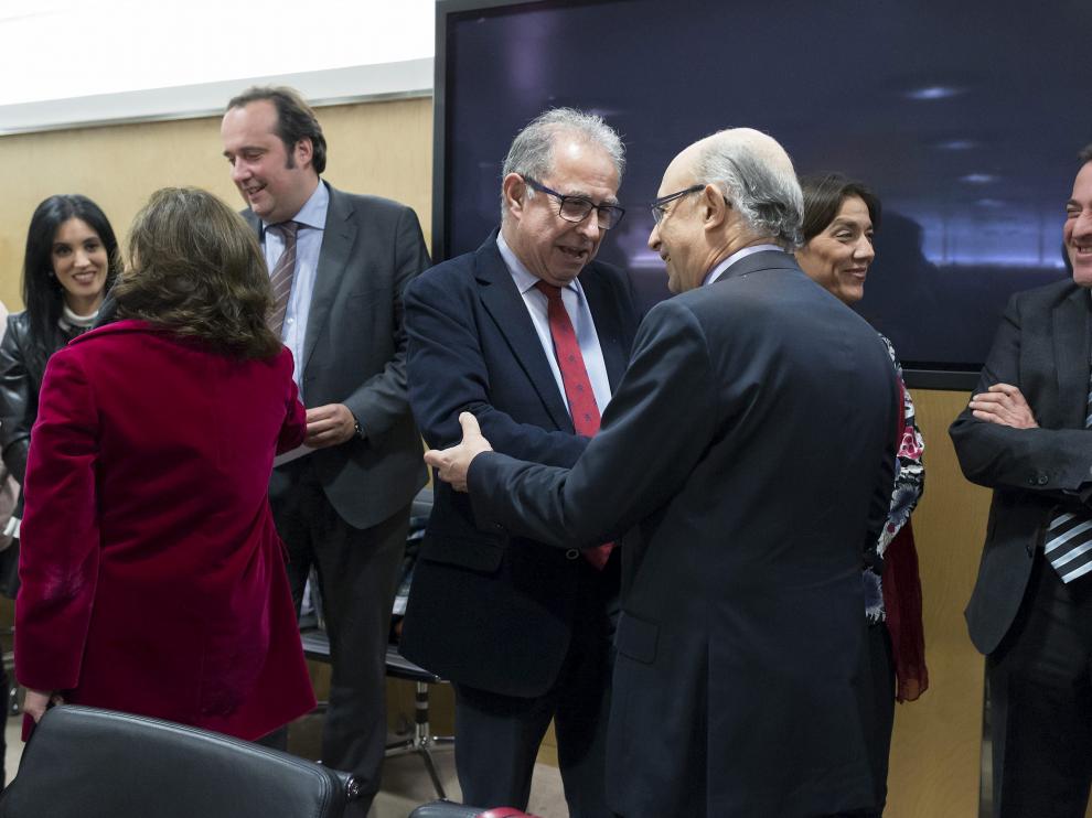 En el centro, Gimeno y Montoro se saludan en el Consejo de Política Fiscal. De espaldas, la vicepresidenta Sáenz de Santamaría