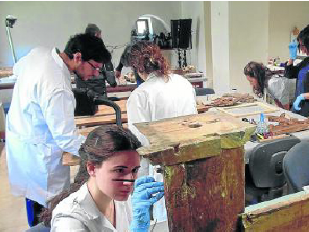 Especialistas trabajando en las piezas de un retablo.