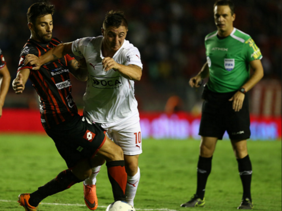 Jonathan Ferrari, con el uniforme rojo y negro del Patronato de Paraná, su actual equipo, intenta frenar a un rival del Independiente de Avellaneda en un partido de la liga argentina.