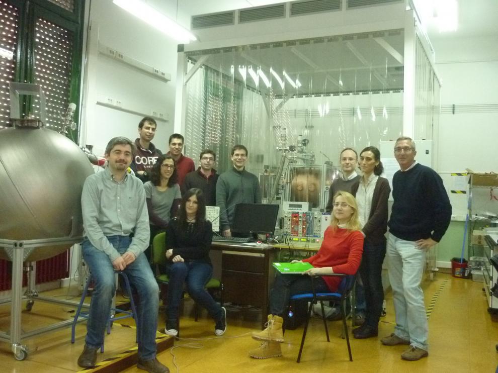 Igor García Irastorza (izquierda), junto a parte de su equipo de investigadores, delante del detector TREX-DM.