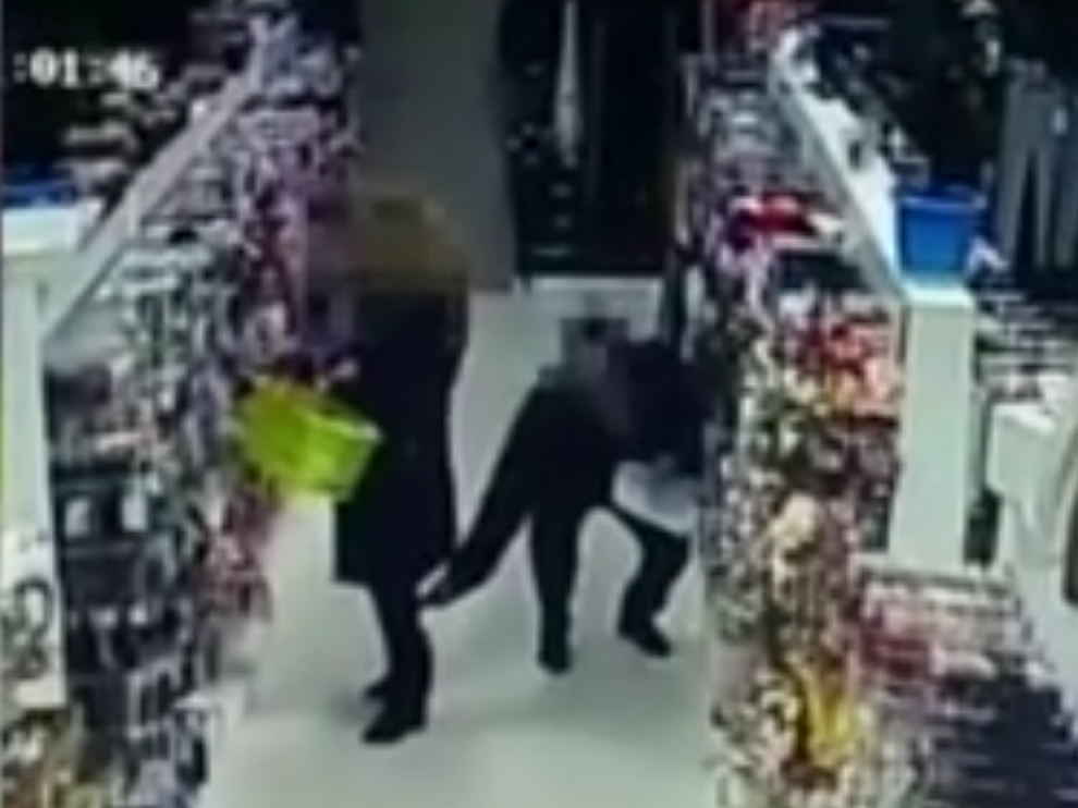 El hombre pone el móvil bajo la falda de la señora, que no advierte lo que está ocurriendo.