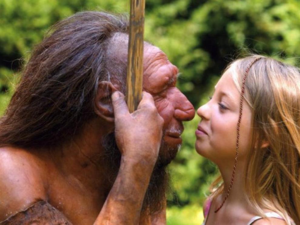Una niña observa una reproducción de un neandertal