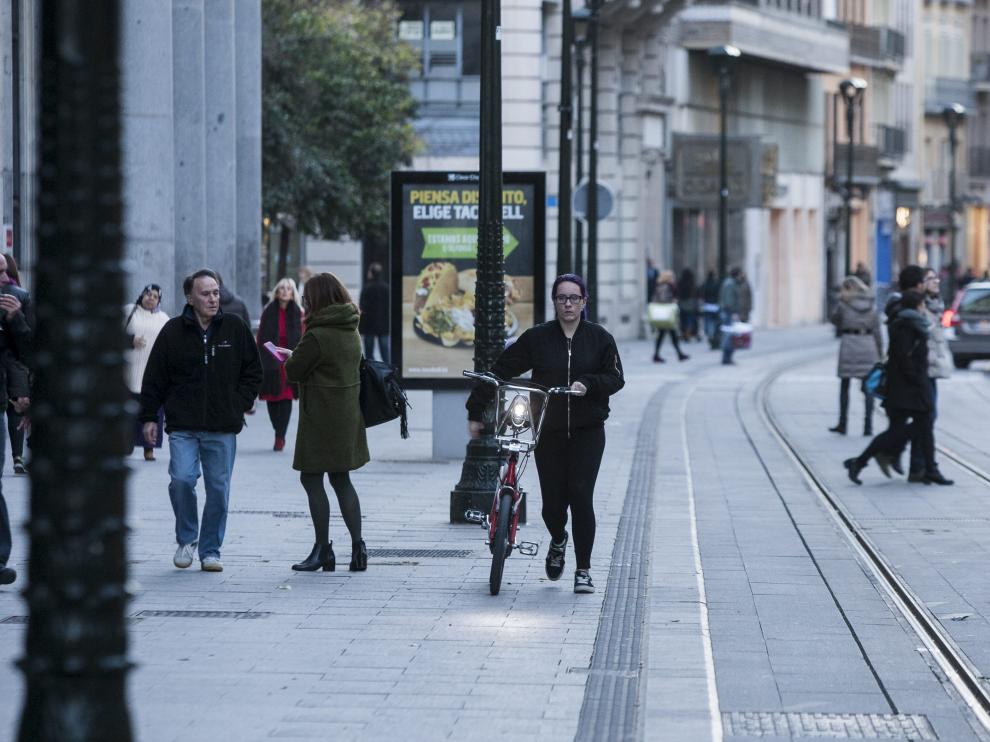 Una usuaria del servicio Bizi, en el Coso de Zaragoza, junto al trazado del tranvía.