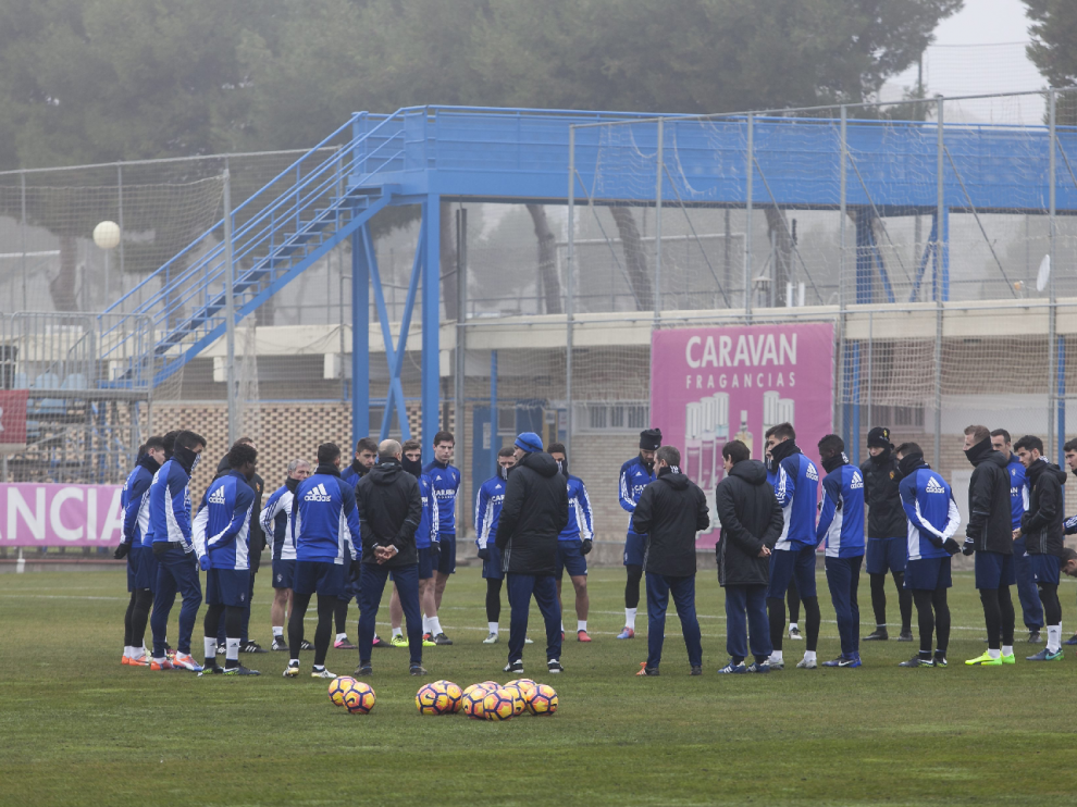 Raúl Agné, en el centro del corrillo de la plantilla, explica sus intenciones antes de iniciarse la sesión preparatoria en la Ciudad Deportiva.