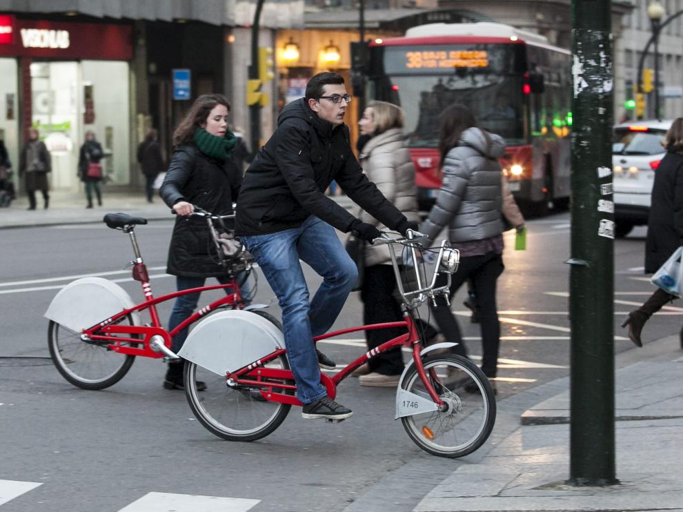 Dos usuarios del servicio público de bicicletas de alquiler Bizi, en el Coso de Zaragoza