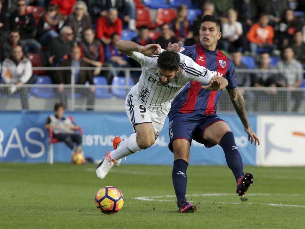 Jesús Valentín pugna una pelota con Toché, delantero del Real Oviedo.