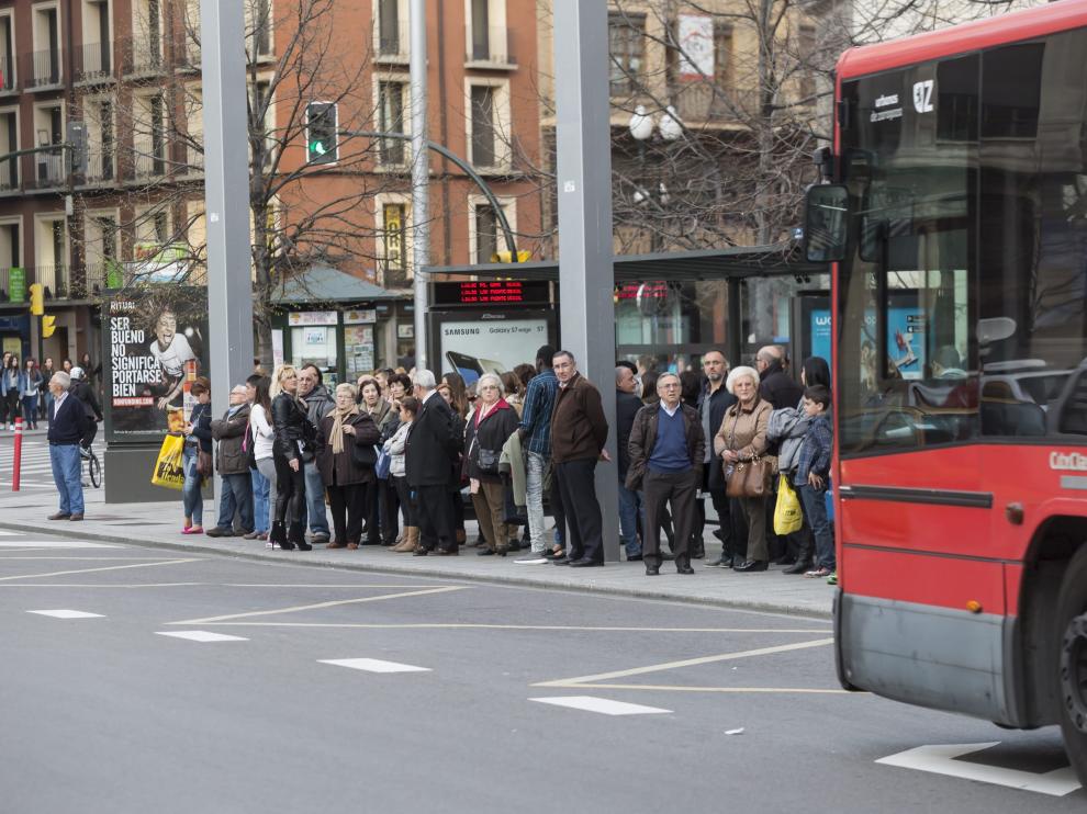 Un grupo de usuarios espera la llegada de un autobús.