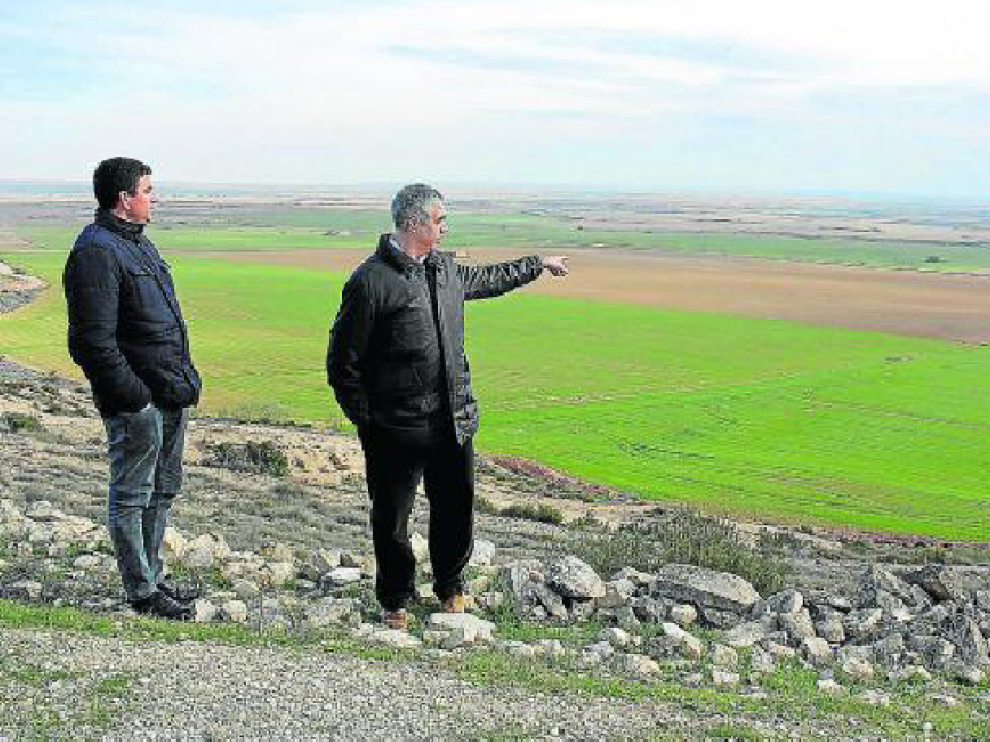 El agricultor Francisco Cruellas y el presidente Ignasi Serviá señalan parte de la zona a transformar.