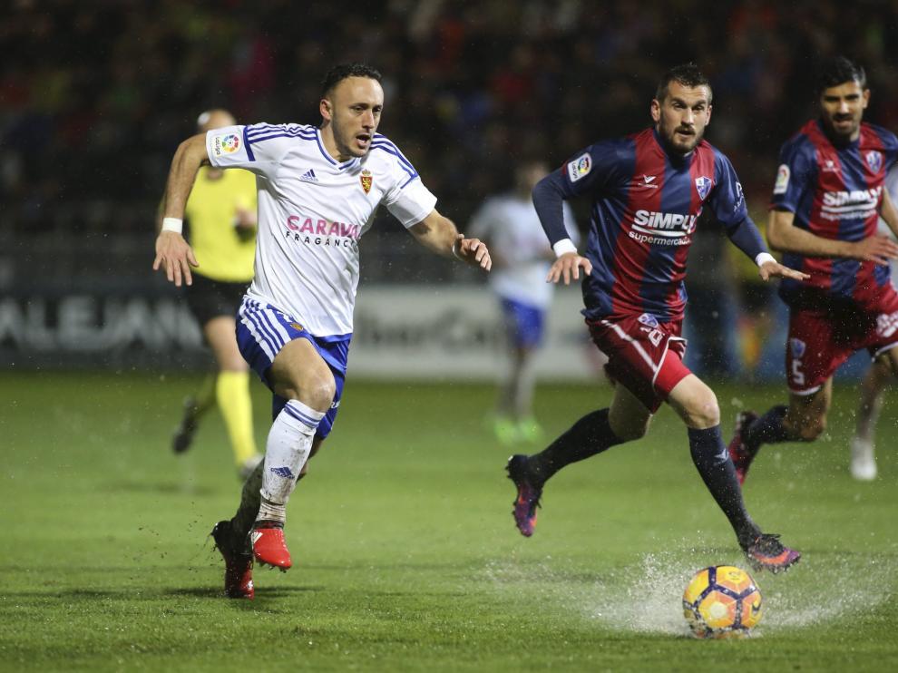 Xumetra conduce el balón sobre el césped mojado de El Alcoraz.