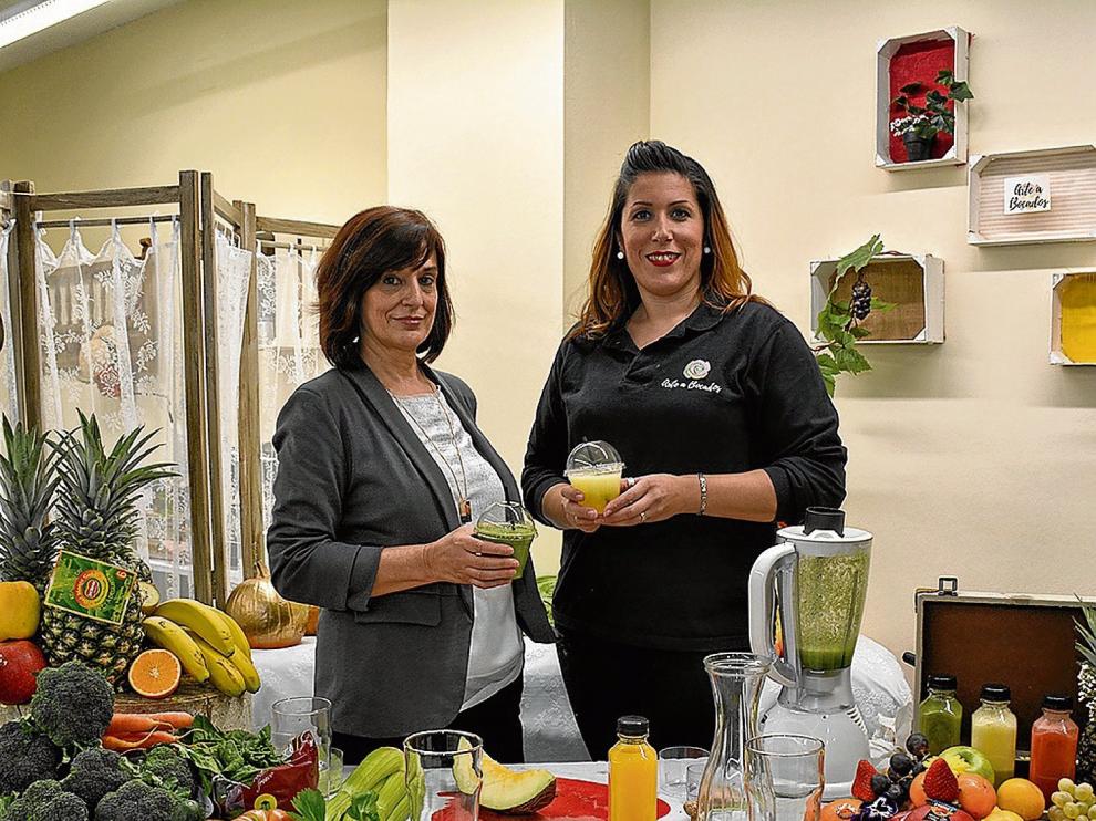 La 'coach' nutricional Asun Armas y Eva Muniesa, propietaria de Arte a Bocados, preparando zumos verdes.
