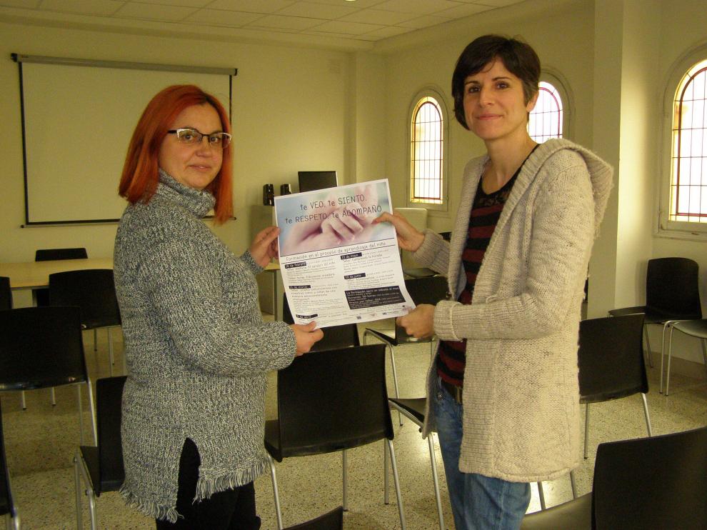 Montse Jubany (izq.) y Ana Martínez (dcha.) en la antigua biblioteca con el cartel de las jornadas.