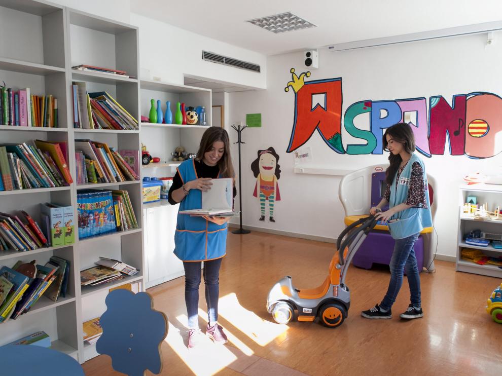Voluntarios de Aspanoa en la sala de juegos de la planta de Oncopediatría del hospital Infantil.