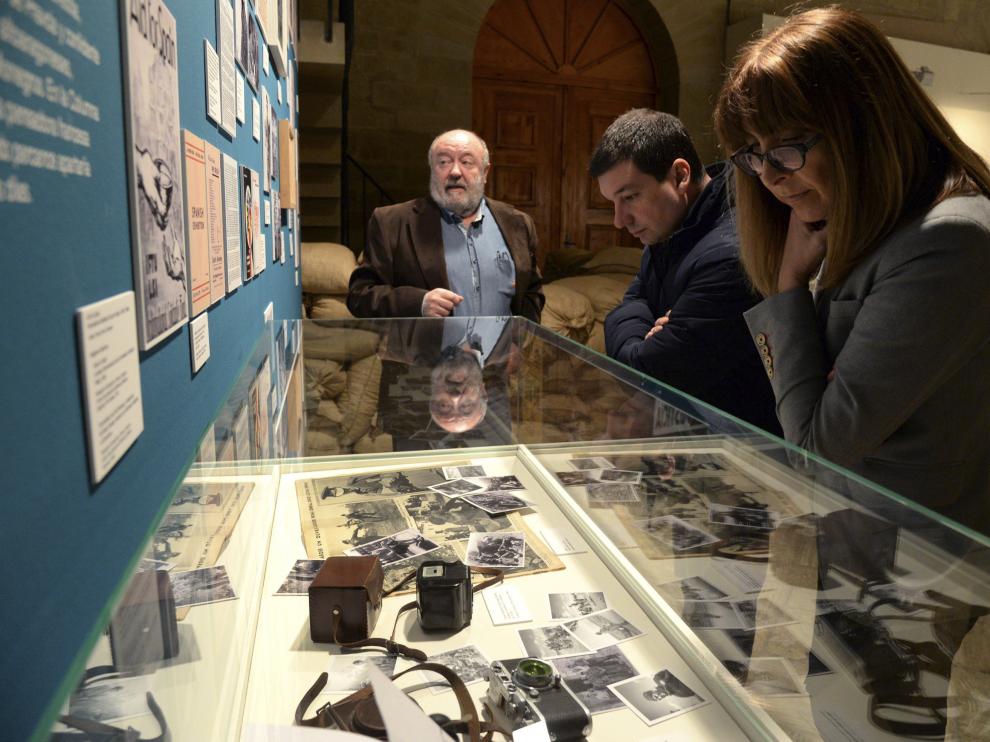 Dos personas observan unas fotografías de la exposición.