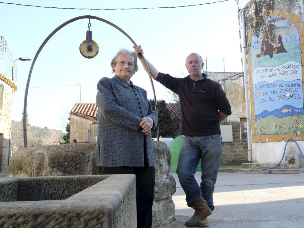 Leonor Corral y el alguacil, Fermín Ortas, cerca del depósito con un mural de la lucha contra la presa.