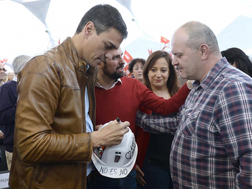 El exsecretario general del PSOE y candidato a las Primarias, Pedro Sánchez, firma un casco como gesto de apoyo al carbón autóctono de un minero leonés, que ha acudido al acto celebrado hoy en Valladolid.