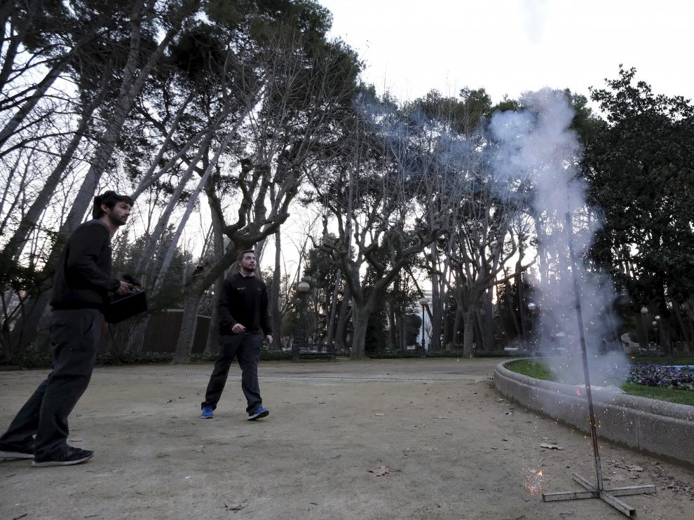 Operarios de Ambién lanzan los cohetes junto a los pinos del parque Miguel Servet.