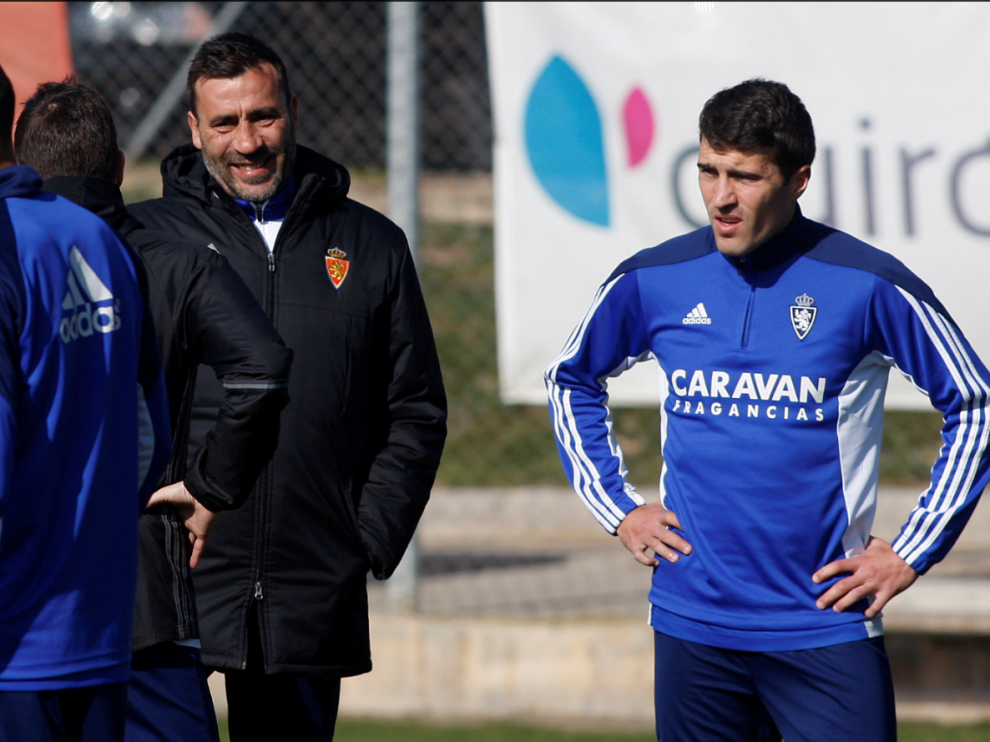 Raúl Agné charla con Zapater y Cani (éste, de espaldas) en el entrenamiento de este lunes en la Ciudad Deportiva del Real Zaragoza.
