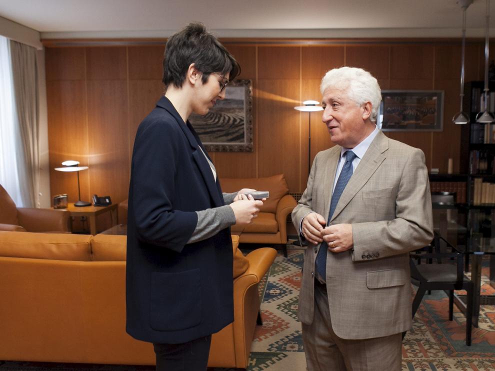 La presidenta de las Cortes de Aragón, Violeta Barba, recibe el pendrive de la memoria del Justicia de Aragón que le entrega Fernando García Vicente.