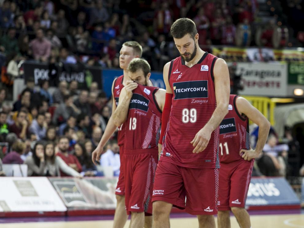 Los jugadores del Tecnyconta Zaragoza se retiran a los vestuarios, cabizbajos, tras encajar una nueva derrota en casa.
