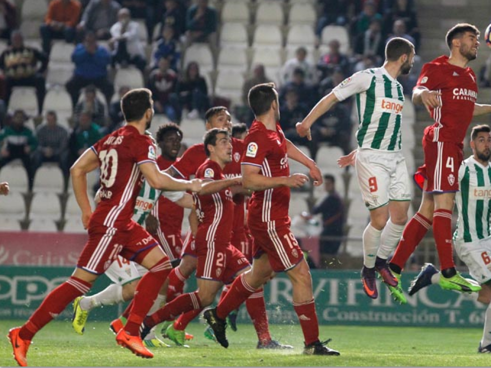 Cabrera intenta despejar de cabeza, ante la mirada de medio equipo zaragocista, un centro sobre el área de Saja en el último Córdoba-Real Zaragoza.