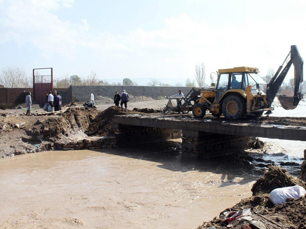 Trabajos para recomponer un puente desbordado por las aguas de un río debido a las inundaciones registradas en el norte de Irán, al sur de Tabriz.