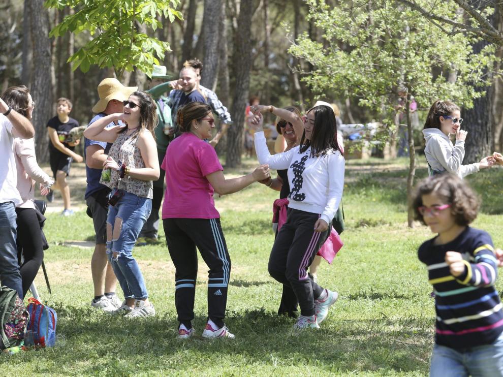 Un grupo de familias con hijos de distintas edades bailan al son de la charanga antes de empezar a tomar el vermú en el cerro.