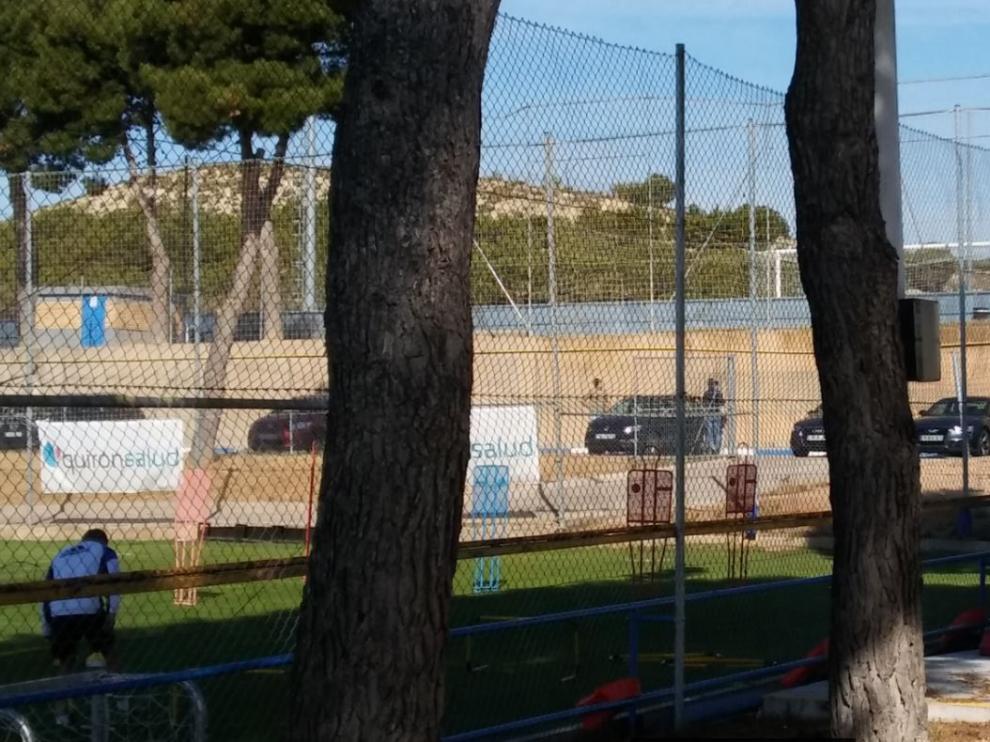 Feltcher, al fondo, sube al coche para marcharse de la Ciudad Deportiva antes del inicio del entrenamiento de este lunes.