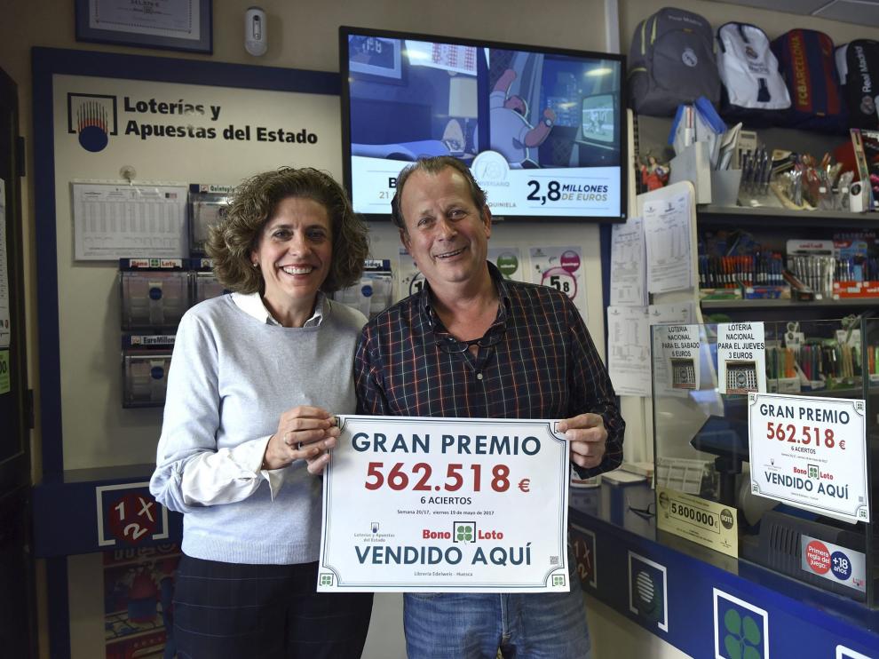 Pilar Lafarga y Luis Beired posan felices con el cartel que certifica el premio de la Bonoloto.